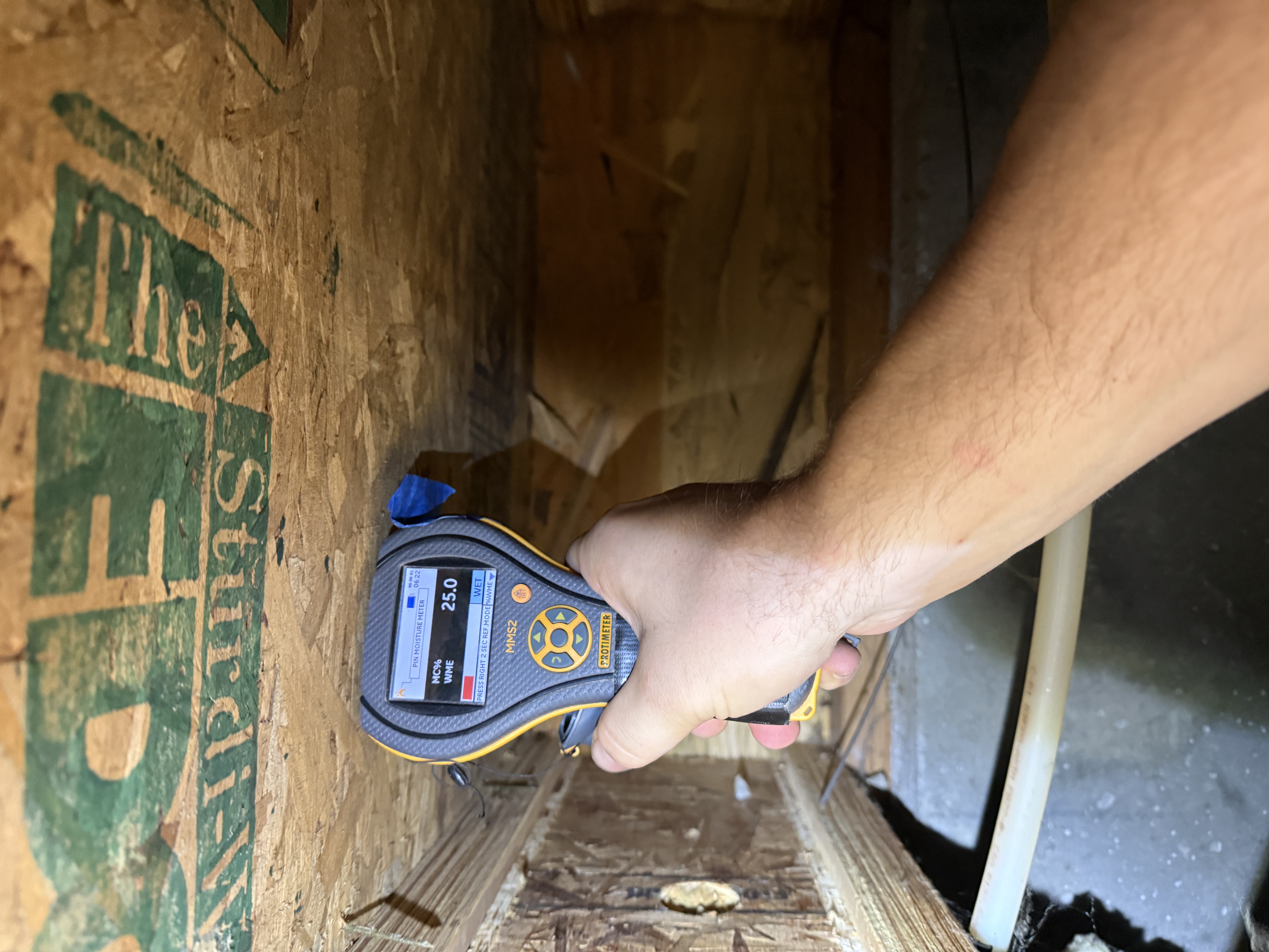 A Peak technician taking a moisture reading in a Treasure Valley crawlspace during an annual inspection